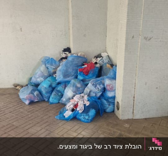 שקיות כחולות מלאות בבגדים מונחות על הרצפה